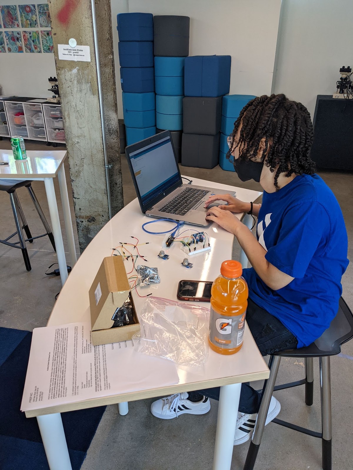 Photo of a student working on their sensor setup with a prototype board and a laptop.