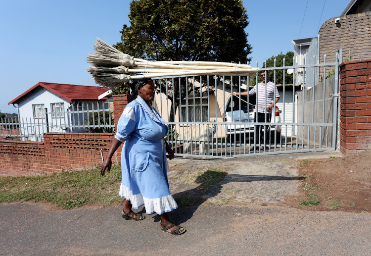 Bezile Mthethwa, 54, a street vendor interacts with a potential customer as she walks past Zintex Road in Havenside, where dogs were vaccinated for rabies.