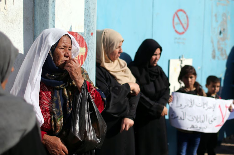 Palestinians whose houses were destroyed during 2014 war, stand outside a UN-run school where they try to take refuge to protest against UNRWA's decision to stop paying rents, in the northern Gaza Strip on December 11 2018.