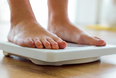 woman checking weight on home scale