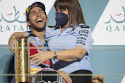 Enea Bastianini (left) celebrates victory on the podium with Nadia Gresini (wife of Fausto Gresini) at the MotoGP of Qatar on March 06, 2022 in Doha, Qatar.