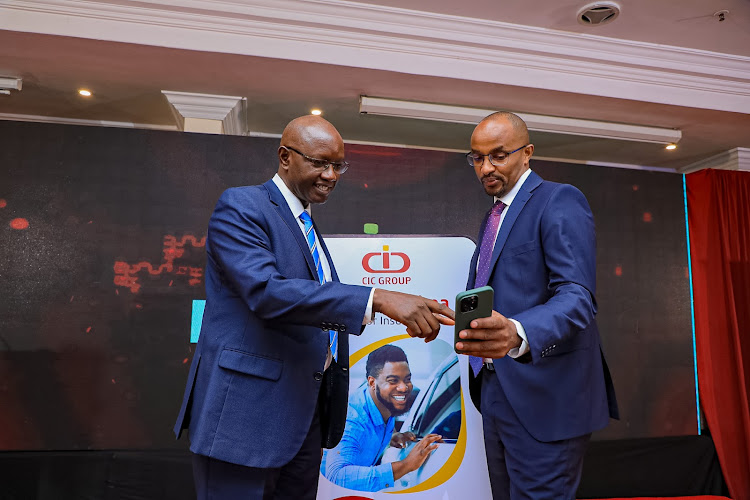 CIC General Insurance MD Fred Ruoro demonstrates the Easy Bima onboarding process to the CIC GCEO Patrick Nyaga