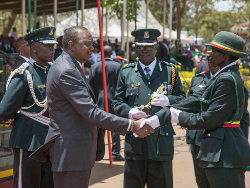 President Uhuru Kenyatta presents awards and trophies to the best graduands during the Kenya Prisons Service Constables, Technicians and Artisans passing out parade at the Kenya Prisons Staff Training College, Ruiru, yesterday / PSCU