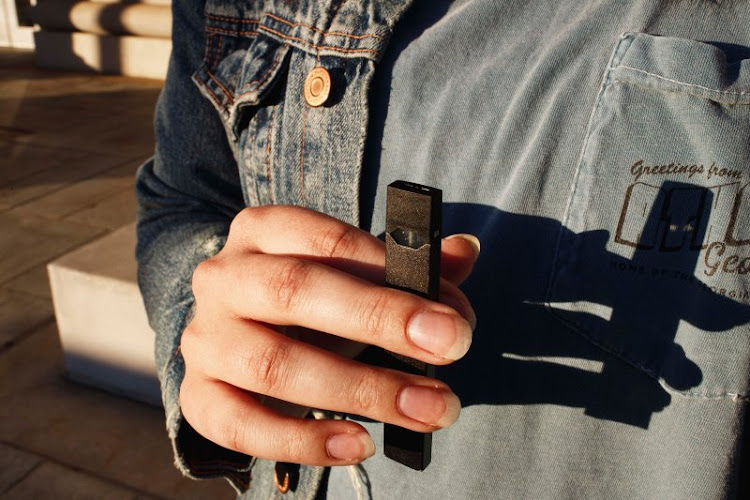 A man holding a Juul vaporiser.