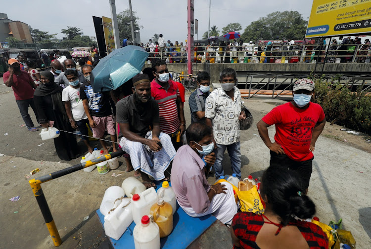 People stand in a long queue to buy kerosene oil due to shortage of domestic gas as a result of country's economic crisis, at a fuel station in Colombo, Sri Lanka March 18, 2022.