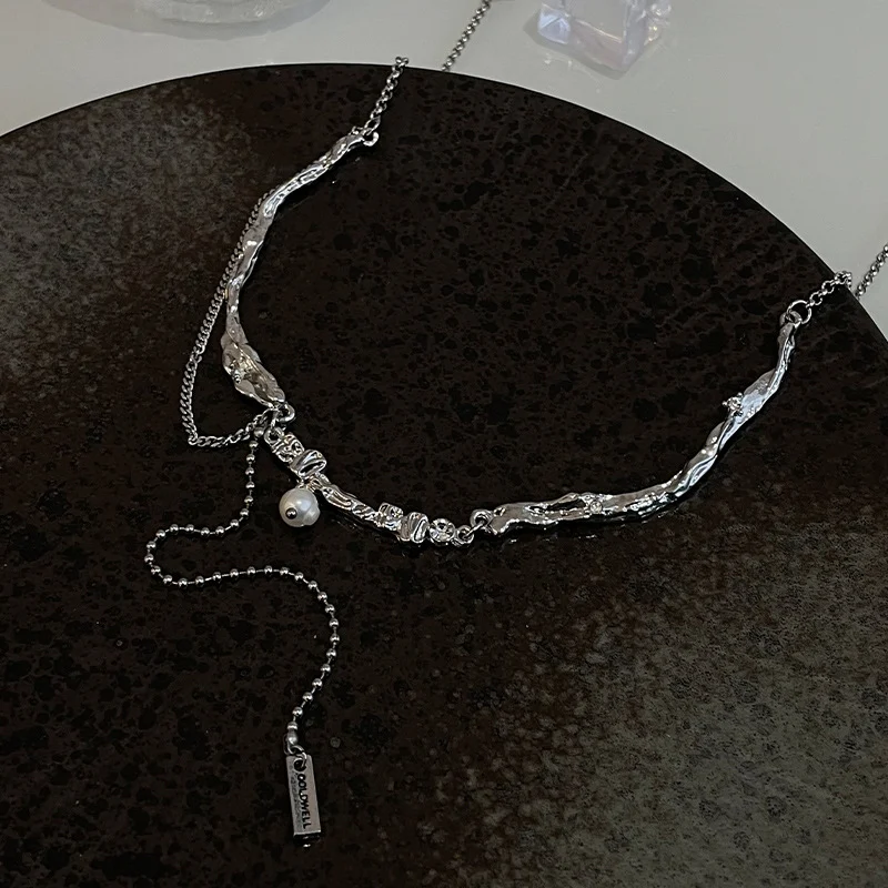Ogrlica sa nepravilnim metalnim biserima i kićankama – elegantan dodatak koji naglašava vaš stil i unosi dozu glamura u svaku odevnu kombinaciju.