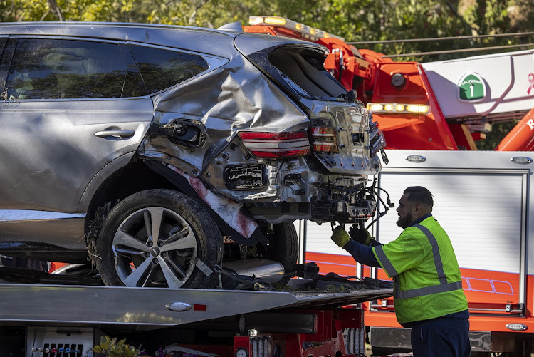 A tow truck operator secures the car that golf legend Tiger Woods was driving when seriously injured in a rollover accident on February 23, 2021 in Rolling Hills Estates, California. Rescuers used hydraulic rescue tools to extricate him from the car where he reportedly sustained major leg injuries. Law enforcement reports that there was no evidence of impairment. He was in town to participate in The Genesis Invitational golf tournament.