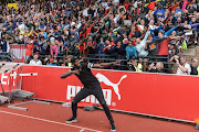 Jamaican sprinter Usain Bolt does his signature pose while greeting school athletes at the Ruimsig Stadium in Roodepoort, Johannesburg. The Olympic Champion  is visiting the country as part of an Athletics South Africa development programme. 