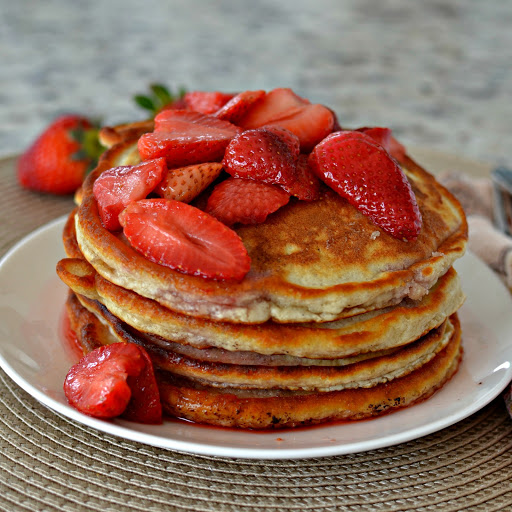 Strawberry Pancakes with Strawberry Sauce are light fluffy pancakes with crispy edges and little bits of sweet strawberries cooked right in them. They are topped with a lightly sweetened strawberry sauce.  