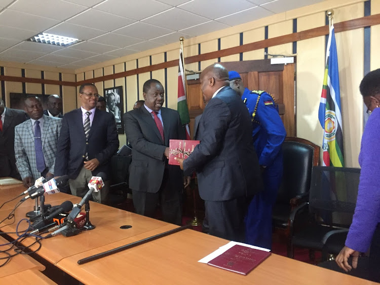 Interior Cabinet Secretary Fred Matiang'i receiving the final report on the recently concluded vetting of all civilian gun holders on June 28, 2019, at Harambee House