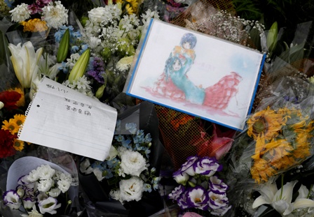 Flowers and a drawing with anime characters dedicated to the victims of the fire are seen left outside the Kyoto Animation building which was torched by arson attack, in Kyoto, Japan, on July 19 2019.