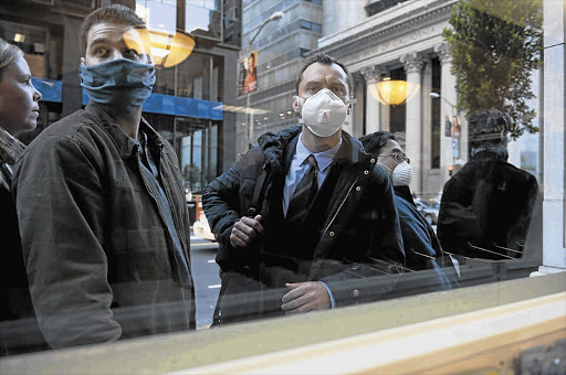 Jude Law, right, as Alan Krumwiede in the thriller 'Contagion', a Warner Bros release