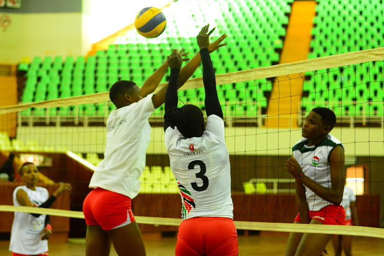 Violet Makuto and Lorine Chebet up in blocks to stop a shot from Gladys Ekaru during teams training at the Moi, stadium indoor arena, Kasarani.