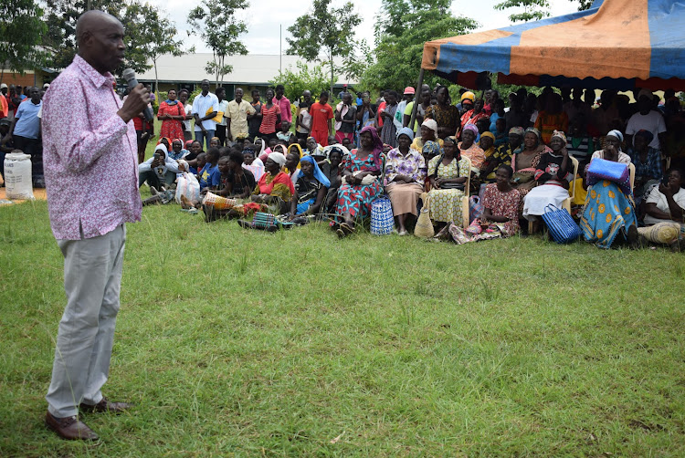 Education CS Ezekiel Machogu speaks to floods affected person in Nyatoto, Suba South constituency during distribution of relief food on December 11,2023