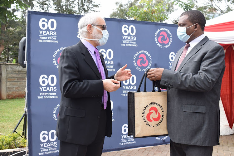 AKUH chief executive Dr Shawn Bolouki presents a token of appreciation to Muturi