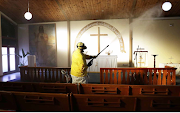 A man sprays disinfectant as he sanitises the Evangelical Lutheran Church in Belgravia, Athlone, to prevent the spread of Covid-19 in Cape Town.