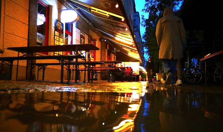 A woman passes empty tables before the late-night curfew due to restrictions against the spread of the coronavirus disease (Covid-19), as city-wide bars and restaurants have to close at 11pm (2100 GMT) until 6am (0400 GMT), in Berlin, Germany, October 14, 2020.