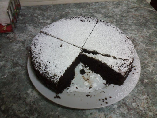 My All in One Chocolate Cake, dusted with caster sugar and served with a dollop of fresh cream.