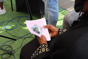 A mourner holds the programme at the funeral service of Tshegofatso Pule, who was eight months pregnant when she was found dead earlier this week.