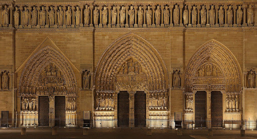 Lower part of the front façade of Notre Dame Cathedral, in Paris, at night. On the upper part, the 28 kings of Judea and Israel. 