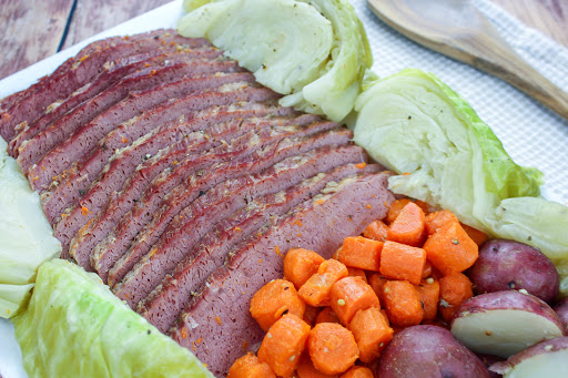 Corned Beef & Cabbage on a platter with carrots and potatoes.