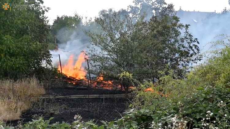 A man extinguishes a fire following shelling as Russia's invasion of Ukraine continues, in Mykolaiv region, Ukraine August 6, 2022 in this screengrab obtained from a social media video.