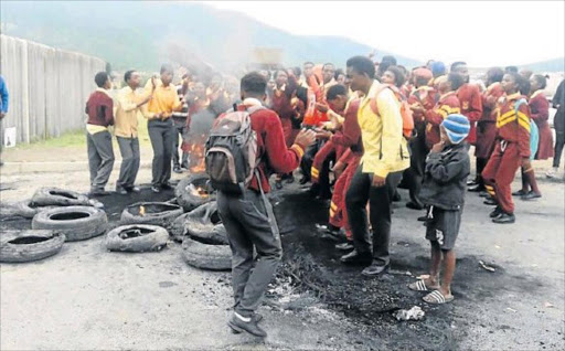 FLAMES OF FURY: Pupils from Healdtown Comprehensive High School burning tyres in front of the Fort Beaufort education district office in protest over teacher shortage Picture: SUPPLIED