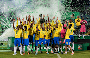 Mamelodi Sundowns players celebrates with the Nedbank Cup trophy after beating Marumo Gallants 2-1 after extra-time at the Royal Bafokeng Stadium on Saturday. 