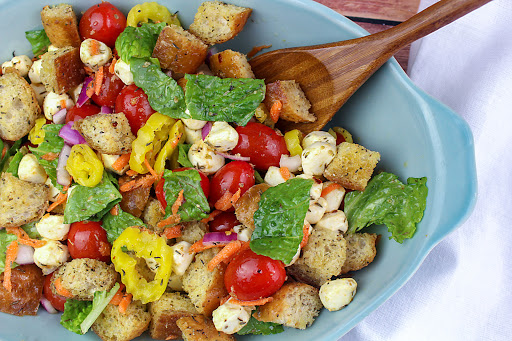 Panzanella salad in a bowl with a serving spoon.