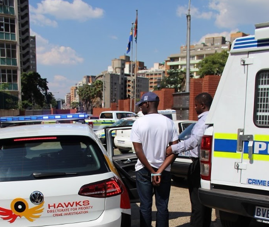 The Hawks have arrested two of their own members and a Hillbrow police detective for armed robbery.