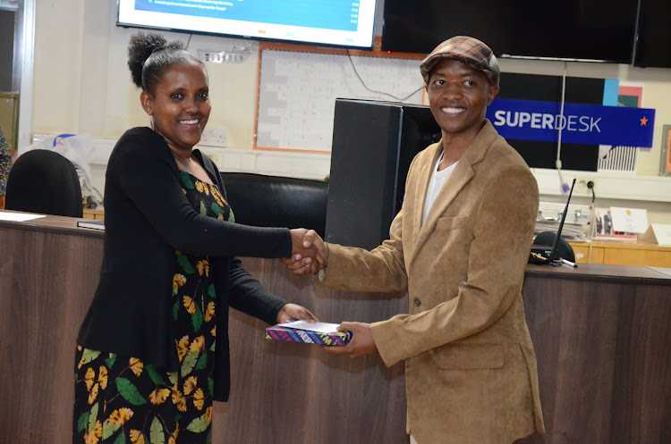 Features editor Tom Jalio receives his gift from deputy news editor Jillo Kadida