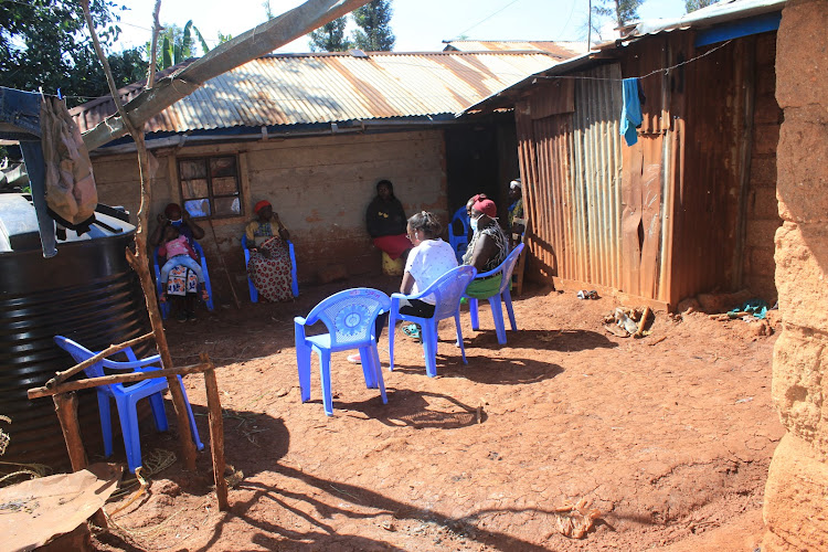 Mourners gather at the home of the family that lost five members at Nyakahura village in Kangema.