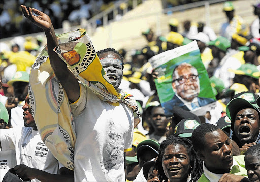 Zanu-PF supporters cheer President Robert Mugabe and his wife, Grace, as they enter the National Sports Stadium, in Harare, yesterday