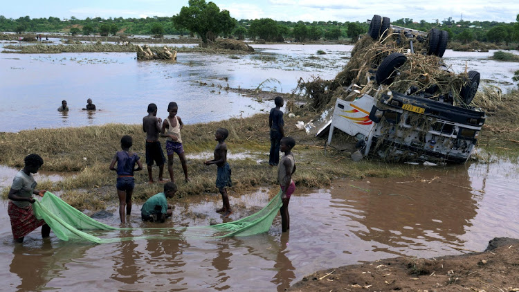 Children use a mosquito net to catch fish near a wreck, washed away during tropical storm Ana on the flooded Shire River, in southern Malawi, January 26 2022. Picture: ELDSON CHAGARA