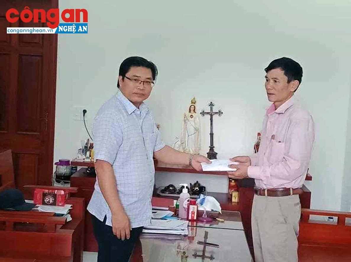 Linh mục Trần Xuân Thùy (trái), quản lý Tòa giám mục Giáo phận Vinh trao tiền ủng hộ cho Ủy ban MTTQ xã Nghi Diên, huyện Nghi Lộc.