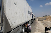 A man works near a truck carrying humanitarian aid to Palestine on a desert road (Cairo - Ismailia) on the way to the Rafah border crossing to enter Gaza, amid the ongoing conflict between Israel and the Palestinian Islamist group Hamas, in Cairo, Egypt, October 14, 2023. 