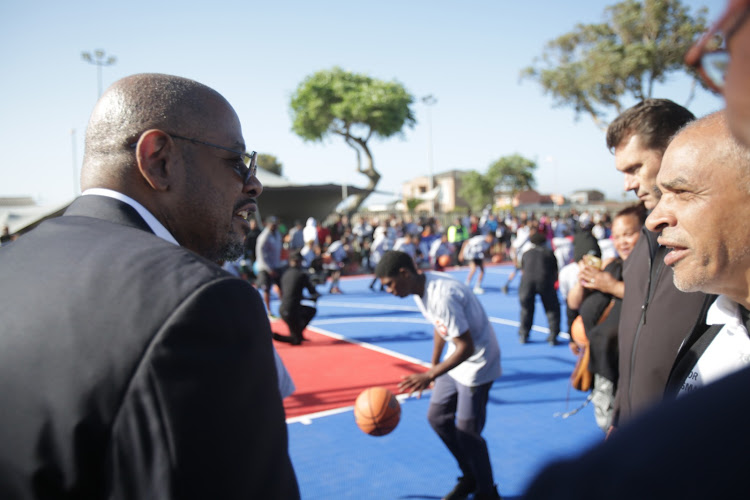 Forest Whitaker chats while boys and girls try the court.