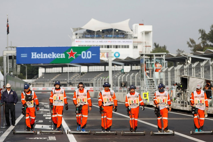 Stewards clean the track after practice the Mexican Grand Prix in Mexico on October 25, 2019.