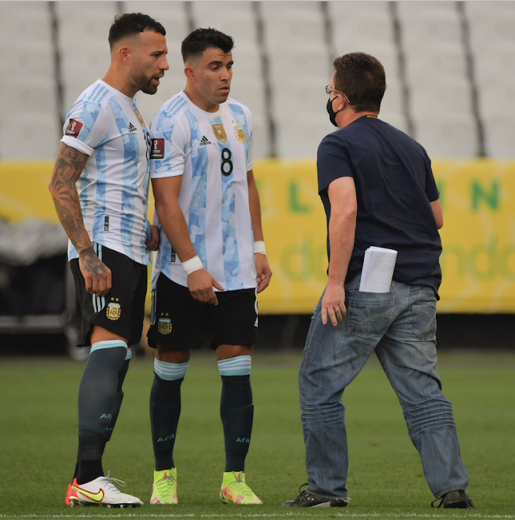 An employee of the National Health Surveillance Agency (Anvisa) argues with Argentina's Nicolas Otamendi (L) and Argentina's Marcos Acuna