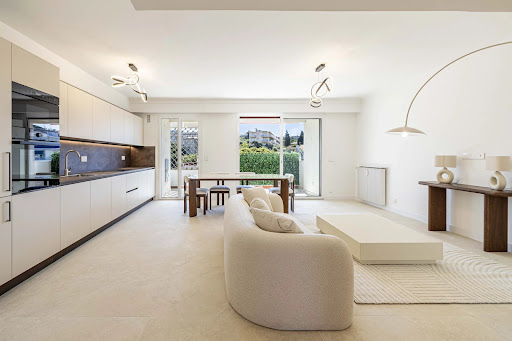 Modern kitchen, living room with sofa and table in this luxury apartment for sale in Nice ($713,295 - 71 m²)