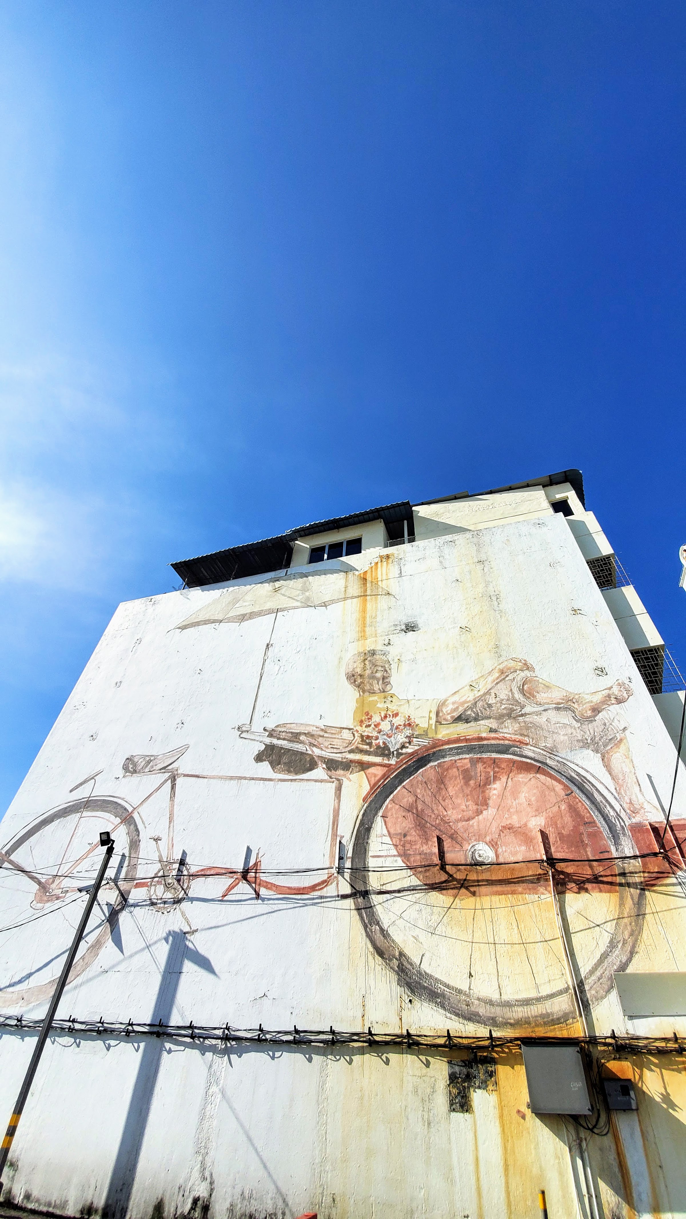 Tips on visiting George Town Street Art: the most famous street art are the ones from Ernest Zacharevic commissioned as part of a Mirrors George Town street art initiative and which are now considered iconic to George Town. This one is Trishaw Man