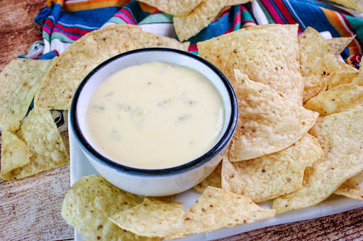 A bowl of Slow Cooker Queso with tortilla chips.