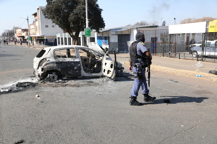 A burnt car in Jules Street, Malvern, after violent protests and looting swept through parts of Johannesburg and Durban.