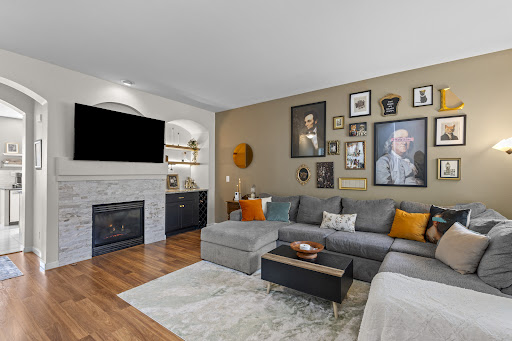 living room with fireplace and large sectional sofa in this luxury house for sale in Centennial ($429,900)