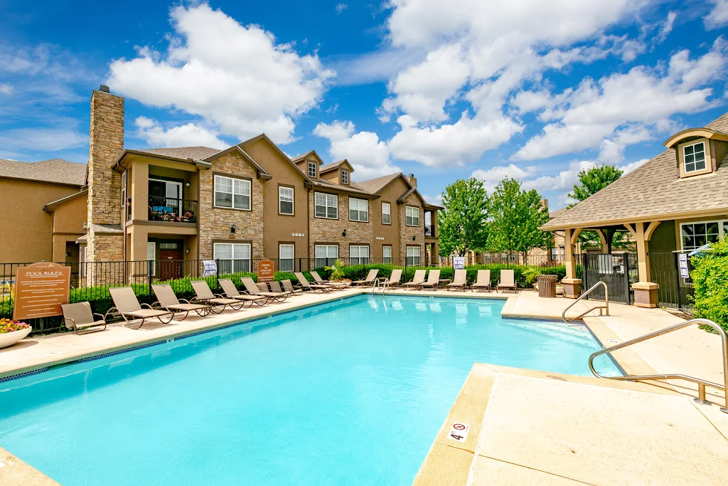 Swimming pool surrounded by lounge chairs and apartment buildings