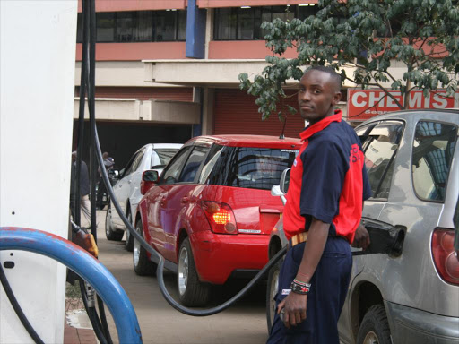 REPRIEVE: A pump attendant serves a customer as vehicles line up for fuel in Nairobi Central Business District. Photo/File