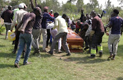 Mourners and fans of Kenyan musician Bernard Obonyo, whose stage name is Abenny Jachiga, carry his coffin away as they proceed his burial under the rules for the suspected coronavirus disease (COVID-19) cases, at Chiga village near Kisumu, Kenya June 12 2020. 
