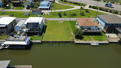 Land purchase in Hitchcock (United States) - Empty lot with canal and houses