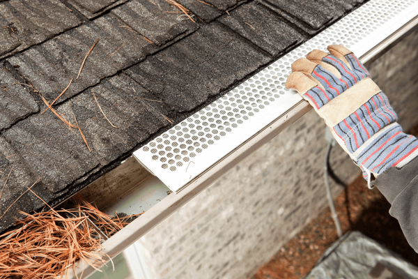 Gutter guard being installed on residential gutters