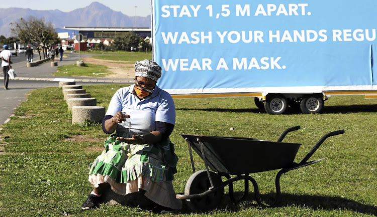 Aida Gxowa in front of an awareness board in Khayelitsha. Residents now have to guard against a resurgence of infections.